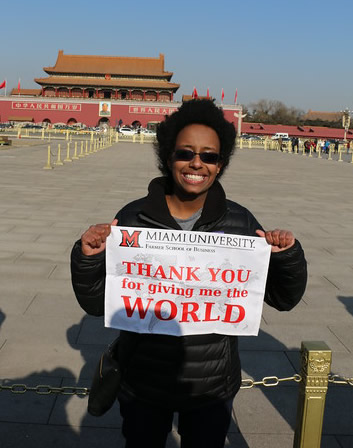 Student traveling abroad, holding sign that says